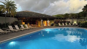 A swimming pool with lounge chairs and a building in the background. - Panoramic Ocean View Kapalua Villa #321 (Lahaina)