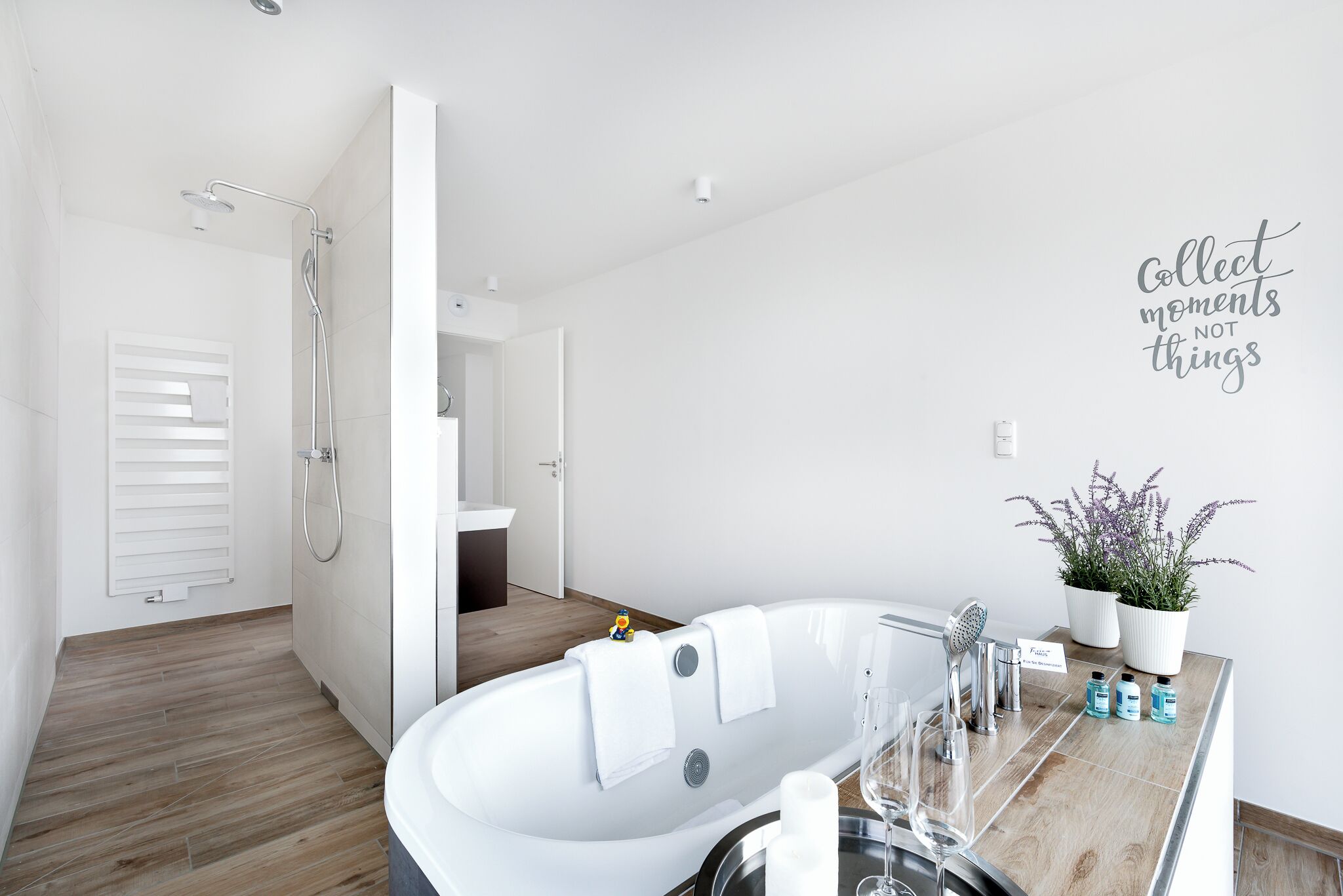 Ein modernes Badezimmer mit einer freistehenden Badewanne, einer Dusche und einem Waschtisch mit Spiegel.