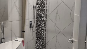 A modern bathroom with a shower, a toilet, and a sink. - New Furn 1 Br/1 Bath/Kitchen, Manila-Univ Belt, AC, Hot water, Wifi, Netflix -u2 (Manila)