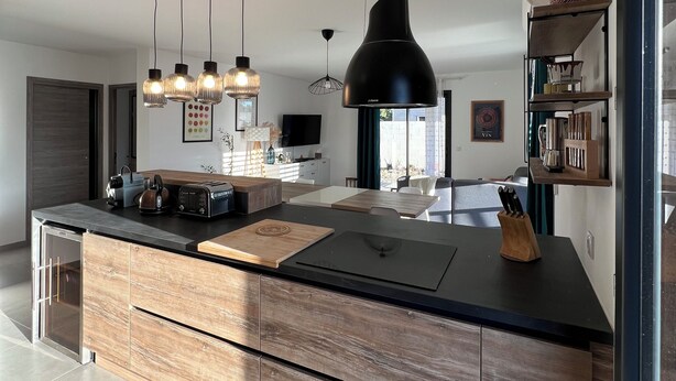 A modern kitchen with a central island, pendant lighting, and a built-in oven.