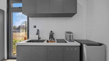 A modern kitchen with a built-in dishwasher, a coffee machine, and a toaster.