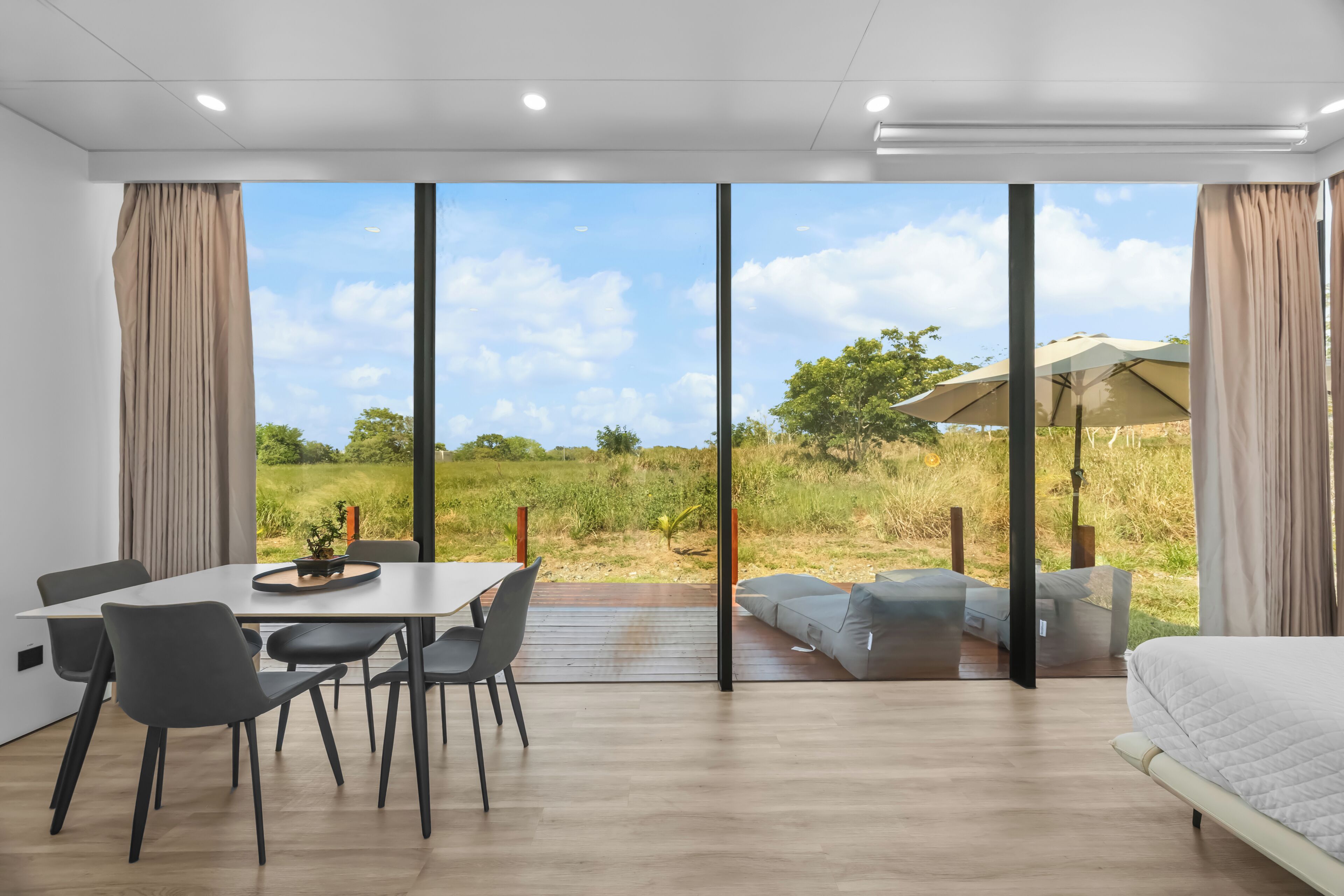 A modern bedroom with a large sliding glass door leading to a patio.