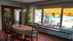 Ein Essbereich mit einem runden Tisch, Stühlen und einem gemusterten Teppich.