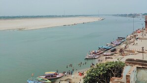 Orilla de río con barcos amarrados y gente realizando diversas actividades.