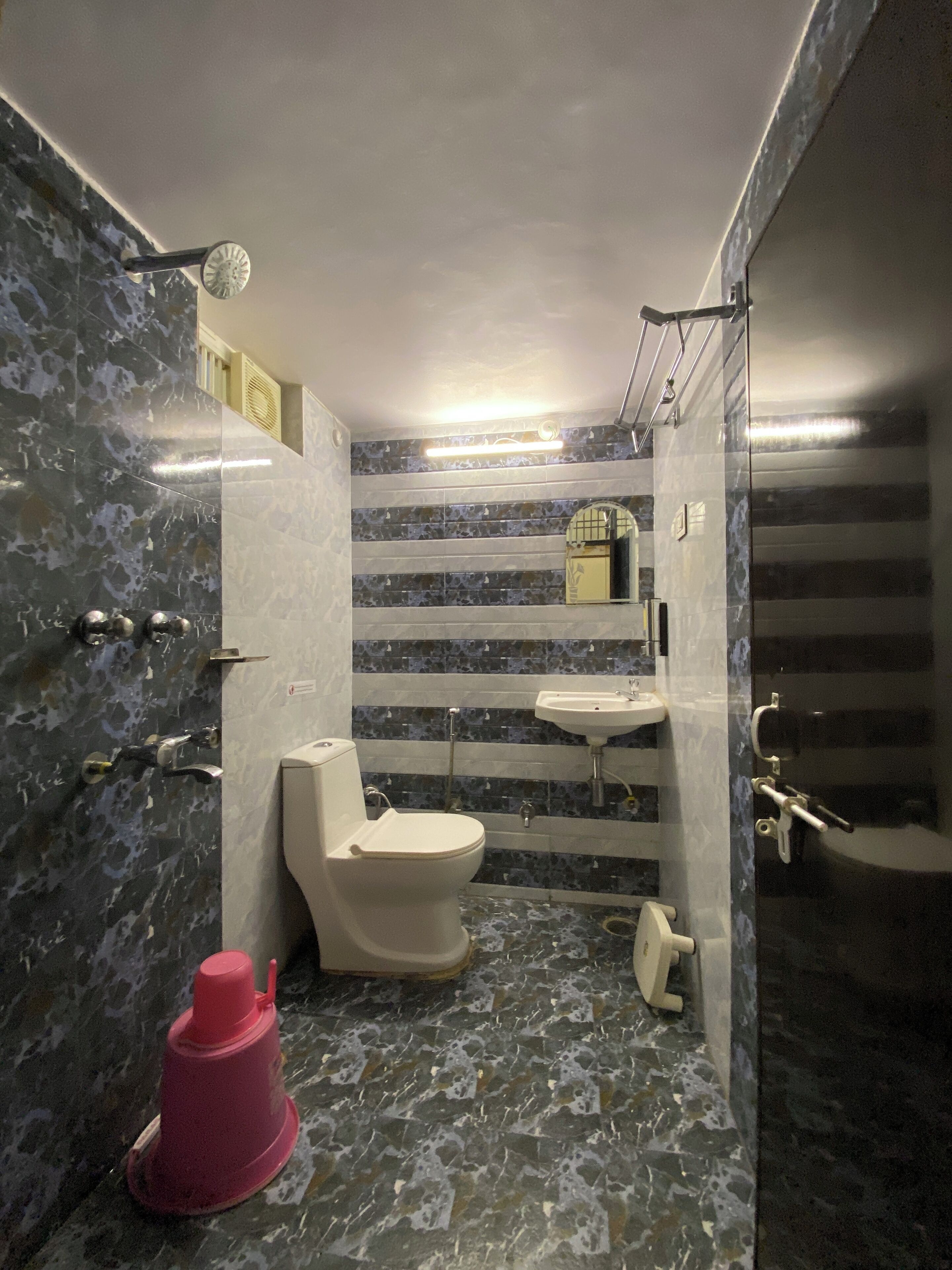 A modern bathroom with a toilet, sink, and shower area.