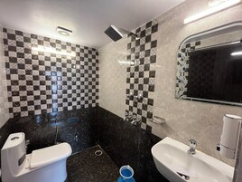 Un baño moderno con un salpicadero de azulejos a cuadros, un inodoro, un bidé y un lavabo.