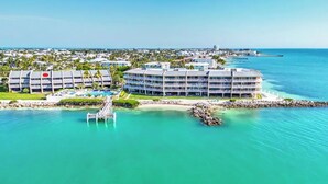 A resort with multiple buildings, a pool, and a pier extending into the water. - Oceanfront Boho Chic Townhouse (Key Colony Beach)