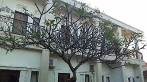 A two-story building with a tree in front. - Agung Residence (Denpasar)