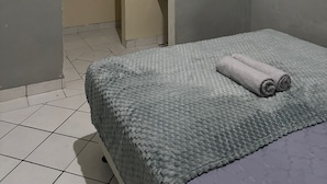 A room with a bed, a bathroom door, and a tiled floor. - Agung Residence (Denpasar)