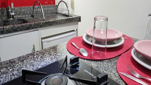Cuina amb fogó de gas, un rentaplat i una paret vermella.