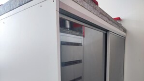 Una habitació amb una porta corredissa que dona a una cuina.
