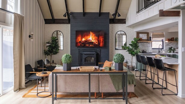 Una sala moderna con chimenea, comedor y cocina.