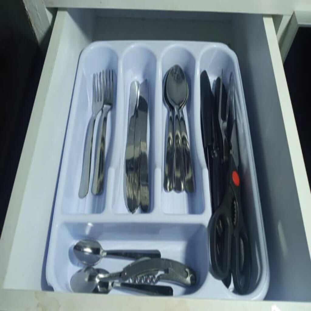 A drawer containing neatly organized silverware and utensils.