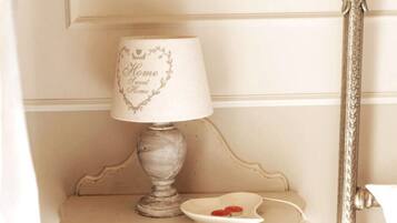 Een lamp in vintage stijl met een hartvormig ontwerp op de lampenkap, geplaatst op een klein tafeltje met een decoratief bord ernaast.