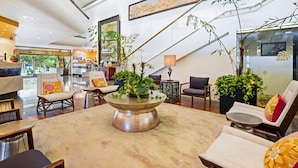 A spacious lobby with a central coffee table, seating area, and potted plants. - Private studio partial ocean/city view, no resort or cleaning fee, with parking! (Honolulu)