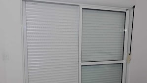 Une pièce dotée d’une grande porte coulissante et d’une fenêtre avec des stores.