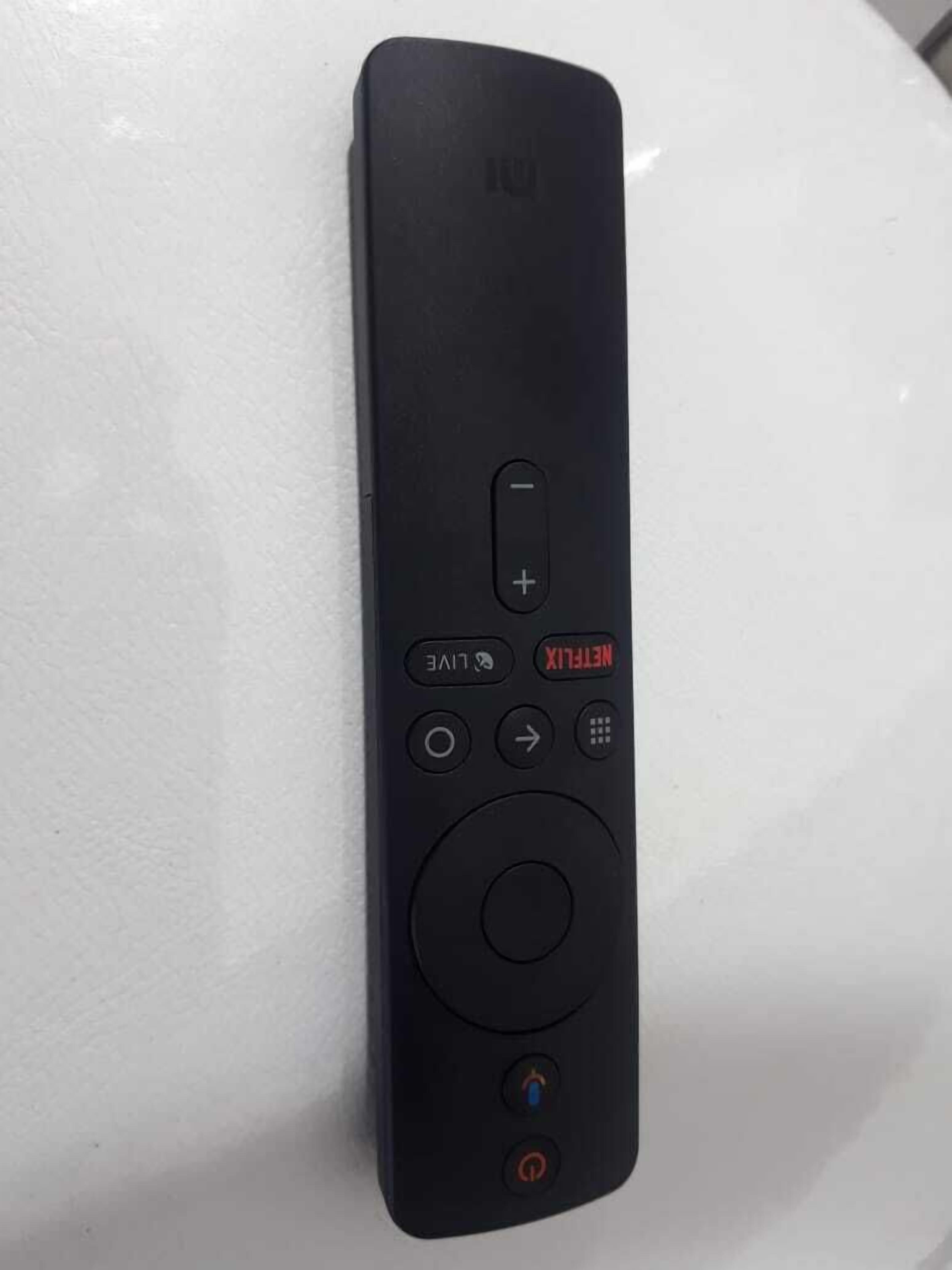 A black remote control with a power button, volume control, directional buttons, and a menu button.