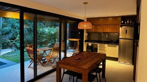 A modern kitchen with a large island, sliding glass doors to a patio, and a hanging pendant light.