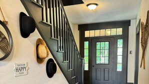 A staircase with black railings, a wooden bench, and a sign that says "THIS IS OUR HAPPY PLACE".