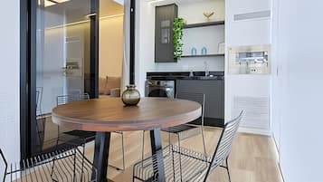 Uma cozinha moderna com uma mesa de madeira redonda, cadeiras pretas e um vaso.