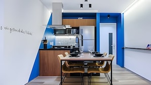 A modern kitchen with a dining area. - HomyCO - Conforto na esqui praia (Niteroi)