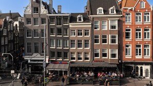 A row of historic buildings with a café named 'Café de Ster' in the center. - CS Hotel (Amsterdam)