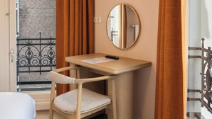 A room with a bed, a desk with a chair, a flat-screen TV mounted on the wall, and a window with curtains. - CS Hotel (Amsterdam)