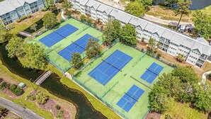 An aerial view of a building with multiple tennis courts, a river, and a bridge. - Flipflops & fun! Charming 2-bedroom ocean view condo at Myrtle Beach Resort (Myrtle Beach)