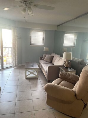 A living room with two sofas, a coffee table, and a ceiling fan.
