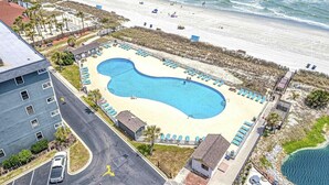 An aerial view of a resort with a large swimming pool, beach access, and a parking area. - Flipflops & fun! Charming 2-bedroom ocean view condo at Myrtle Beach Resort (Myrtle Beach)