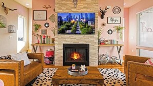 Un salon doté d’une cheminée, d’un téléviseur fixé au mur et de différents éléments de décoration murale.
