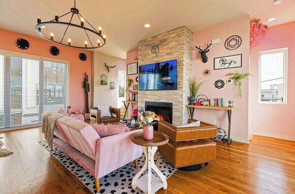 A living room with a fireplace, a television mounted on the wall, and a sofa.