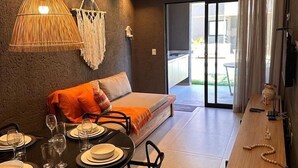 Ein modernes Wohnzimmer mit Essbereich, einer Couch und einem Fernseher.