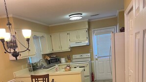 A kitchen with a central island, white cabinets, a microwave, and a stove.