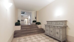 A staircase leading to a second floor, a light-colored wall, and a large, ornate cabinet.