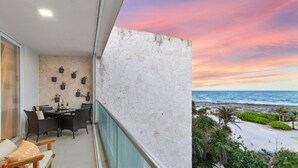 Un balcon avec vue sur l’océan et sur le coucher du soleil.