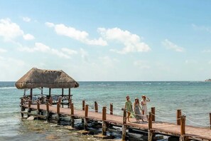 A wooden pier with a thatched-roof structure, leading to a calm sea. - Oceanfront Paradise In Akumal Beach Access (Akumal)
