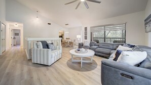 A spacious living room with a ceiling fan, a dining area, and large windows. - Spacious 4-bedroom Key Largo Villa steps from the pool, pickleball, & marina.  (Key Largo)