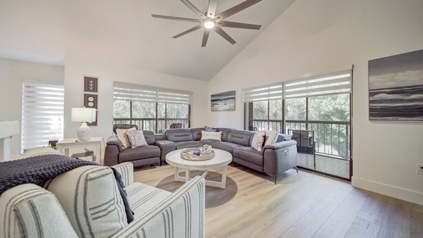 A spacious living room with a large sectional sofa, a round coffee table, and a ceiling fan. - Spacious 4-bedroom Key Largo Villa steps from the pool, pickleball, & marina.  (Key Largo)