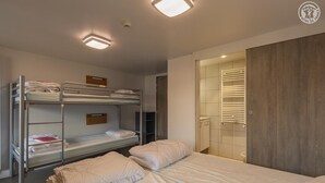 Une chambre de dortoir avec des lits superposés, une armoire et un dressing.
