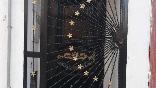 A black metal door with decorative patterns and a small step leading up to it. - Tranquil Rooms in Agadir (Agadir)