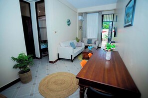 Relax in this inviting living room with a dining table, sofa, and potted plant.