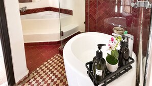 A modern bathroom with a freestanding bathtub, a glass-enclosed shower, and a vanity with a mirror. - Suite in the heart of Marrakech's medina (Marrakech)