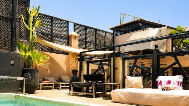 A pool area with lounge chairs, a cactus plant, and a pergola. - Suite in the heart of Marrakech's medina (Marrakech)