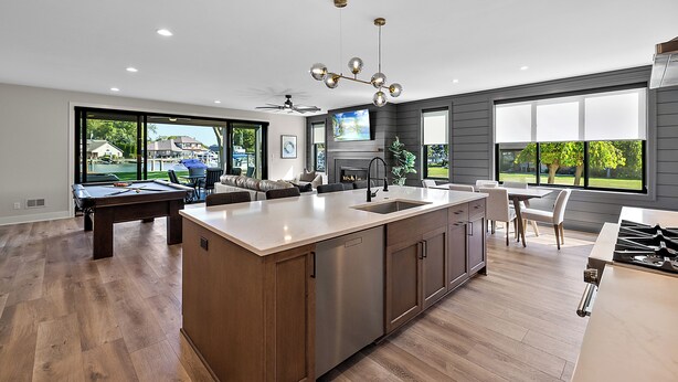 A modern kitchen with a central island, a dining area with a table and chairs, and a pool table. - Manse Island: Sizzle by the River – Hot Tub, Fire Pit, and Summer Fun (Harrison Township)
