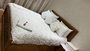A neatly made bed with a white duvet, pillows, and a folded towel. - Super City Center Apartment with Parking  (Tanger)