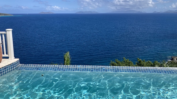 A pool with clear blue water and a view of the ocean. - Luxurious Villa w/ Stunning Ocean Views & Pool (St. Thomas)