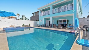 A two-story building with a pool, outdoor furniture, and a basketball hoop. - Upscale New Build with Private Pool, Steps to the Beach (South Padre Island)