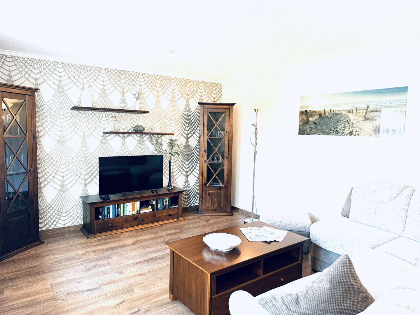 A living room with a TV, wooden cabinets, a coffee table, and a sofa.