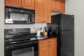 Full-size fridge, microwave, cookware/dishes/utensils